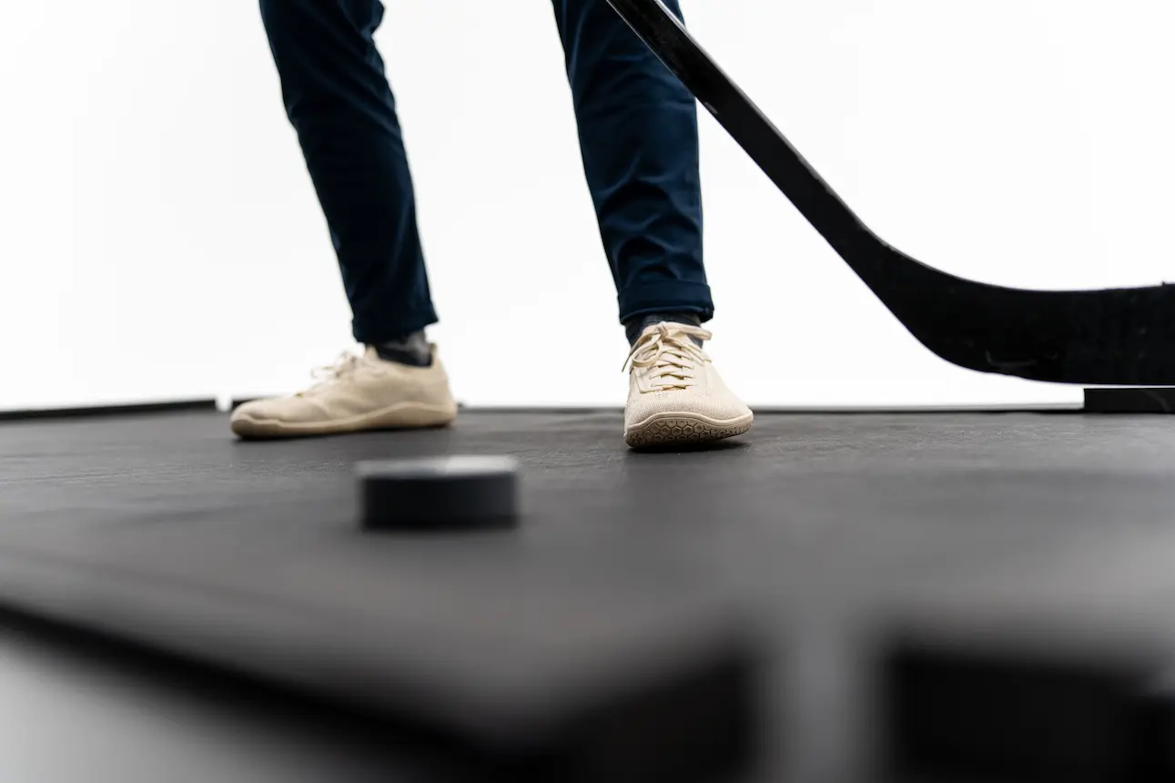 Feet, stick, and Danglepuck on the Danglemat surface